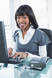 Smiling stylish businesswoman working on computer
