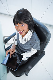 High angle view of smiling pretty businesswoman holding tablet