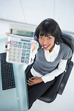 High angle view of smiling businesswoman showing calculator