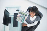 Overhead of smiling businesswoman showing calculator