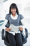 Smiling businesswoman reading newspaper
