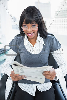 Happy businesswoman holding newspaper
