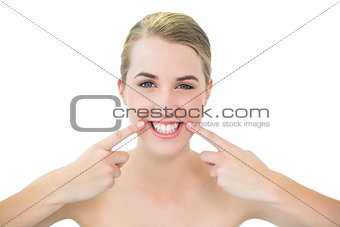 Pretty blonde pointing at mouth wrinkle