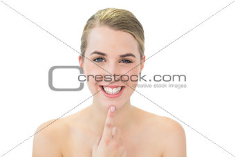 Smiling pretty blonde pointing at her chin