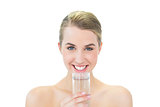 Smiling attractive blonde holding glass of water