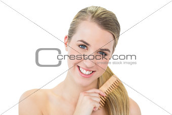 Happy attractive blonde combing her hair
