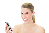 Smiling attractive blonde holding her smartphone