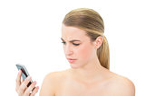 Frowning attractive blonde looking at her smartphone