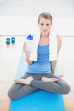 Peaceful pretty blonde in lotus position holding flask