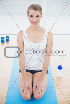 Smiling sporty woman on her knees posing