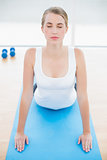 Relaxed fit woman stretching on sport mat