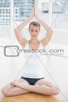 Smiling fit woman in lotus position doing yoga session