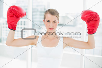 Competitive fit woman with red boxing gloves cheering up