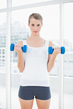 Fit woman exercising with dumbbells