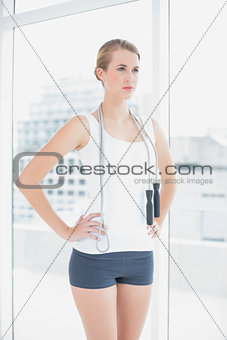 Serious sporty woman holding skipping rope