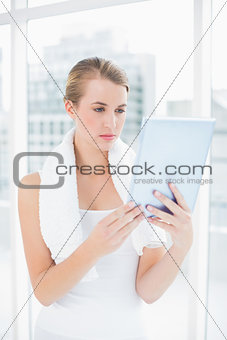 Concentrated sporty woman holding tablet pc