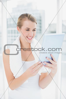 Smiling sporty woman holding tablet pc