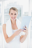 Cheerful sporty woman holding tablet pc