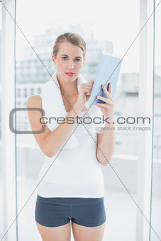Serious sporty woman using tablet pc