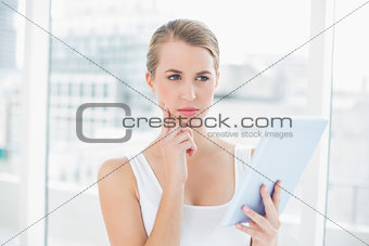 Pensive sporty woman using tablet computer