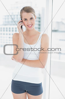 Smiling sporty woman on the phone