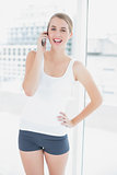 Cheerful sporty woman on the phone