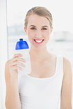 Happy sporty woman holding flask