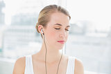 Head shot of relaxed sporty woman listening to music