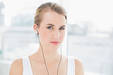 Head shot of content sporty woman listening to music