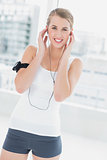 Cheerful sporty woman listening to music