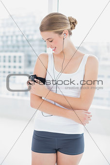 Happy sporty woman changing song on her mp3