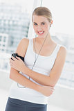 Smiling sporty woman changing song on her mp3