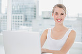 Cheerful blonde using her laptop