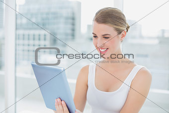 Cheerful cute blonde holding digital tablet
