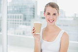 Cheerful cute blonde holding mug of coffee