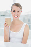 Smiling cute blonde holding mug of coffee