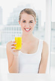 Smiling blond woman holding orange juice