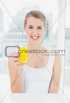 Smiling blond woman holding orange juice