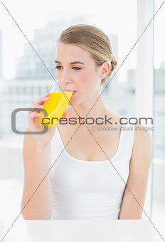 Cute blond woman drinking orange juice