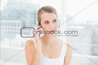 Thoughtful blond woman on the phone