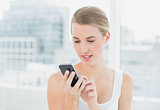 Smiling blond woman text messaging