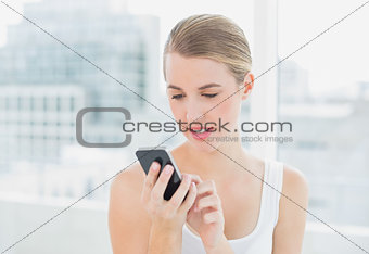 Smiling blond woman text messaging