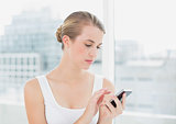 Focused blond woman text messaging