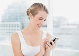 Cheerful blond woman text messaging