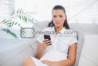 Worried pretty woman holding phone