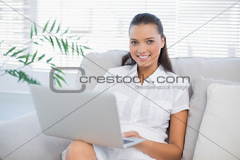 Cheerful pretty woman using laptop