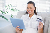 Smiling cute woman buying online using her tablet pc