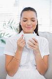 Relaxed pretty woman smelling hot coffee