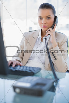 Serious gorgeous businesswoman answering the phone