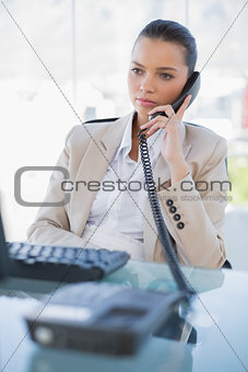 Pensive gorgeous businesswoman answering the phone
